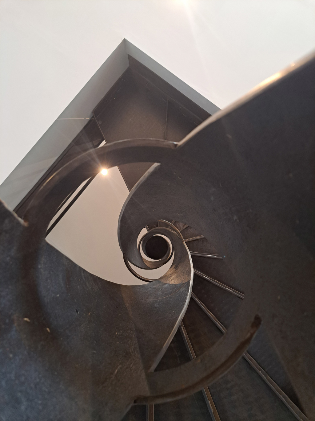 Escalier colimaçon en acier patiné intégré dans un intérieur contemporain – Projet Ellipse