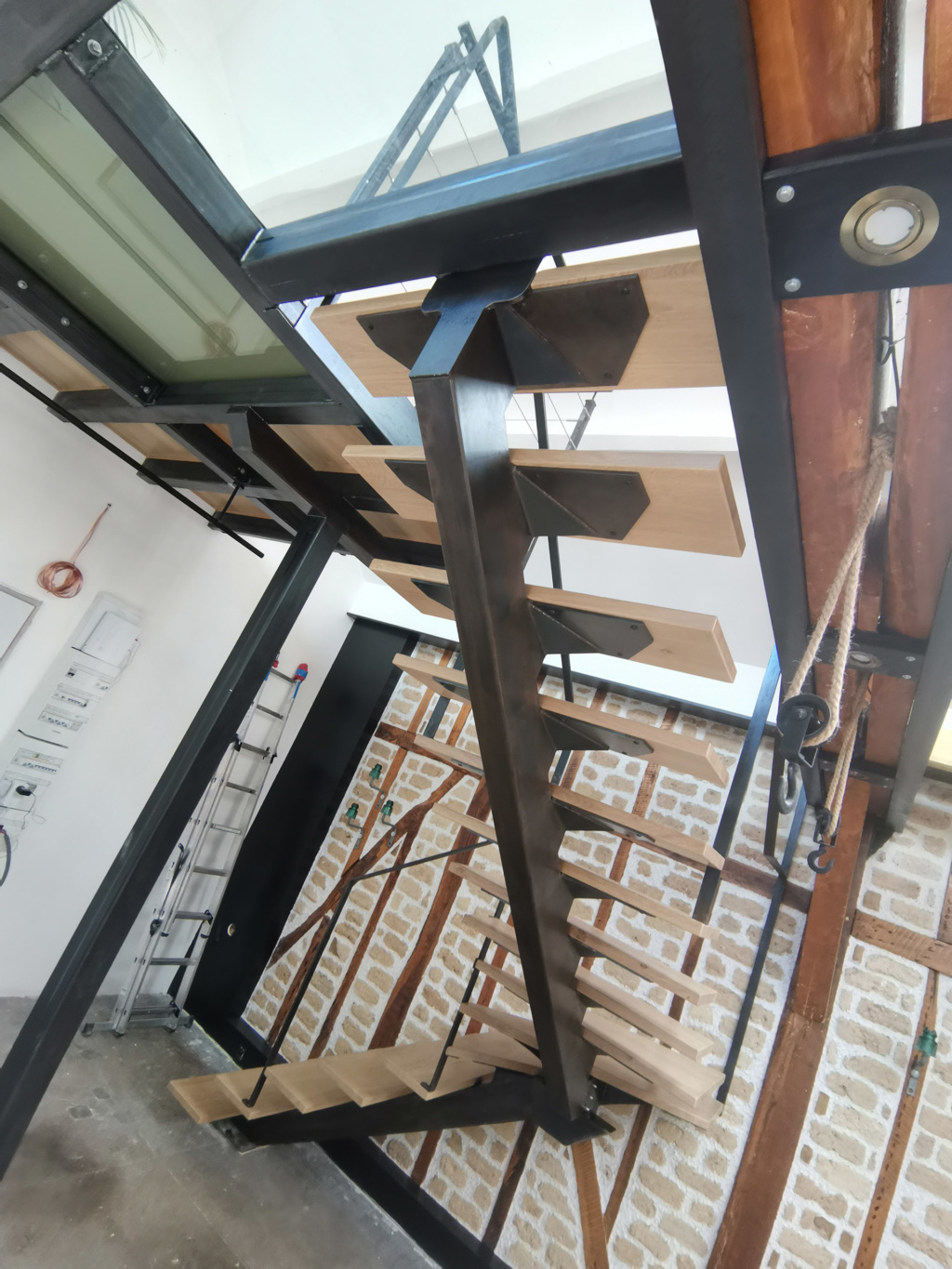 Escalier sur mesure en acier patiné et chêne massif intégré dans un loft contemporain