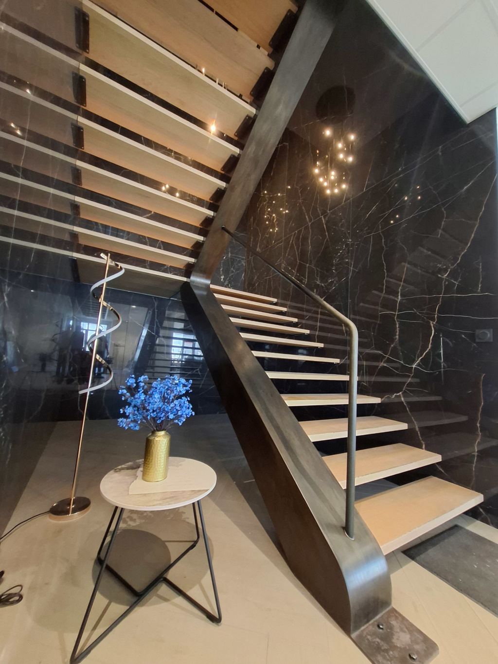 Finition artisanale de l’escalier en acier patiné avec marches en chêne sur mesure